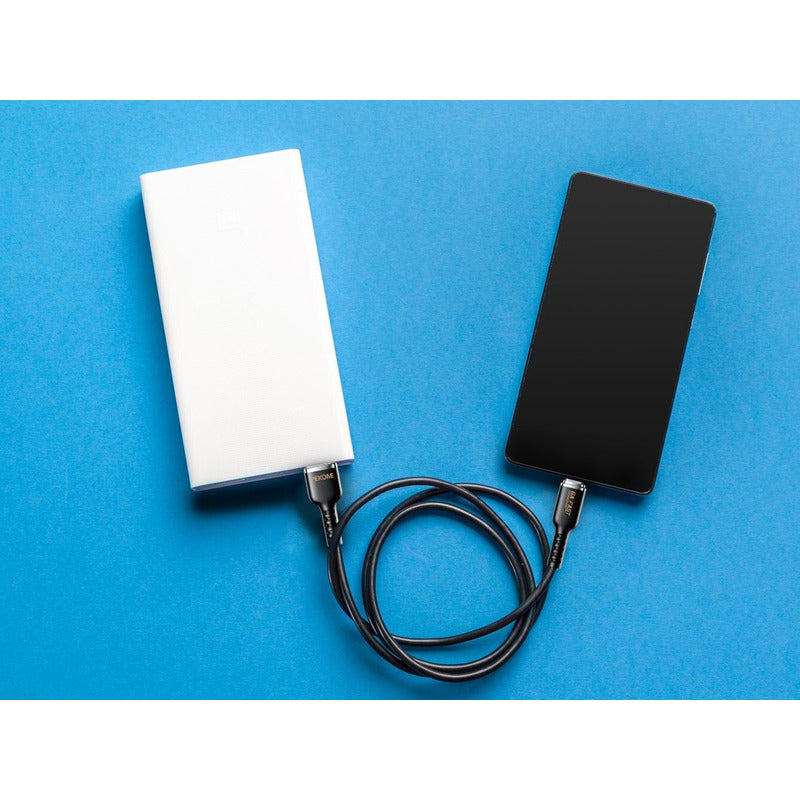 Celular conectado a un dispositivo mediante el Cable De Datos 6a De Silicona Real Serie Tintt Wdc-09a (tyc) color negro, durante la transferencia de datos.