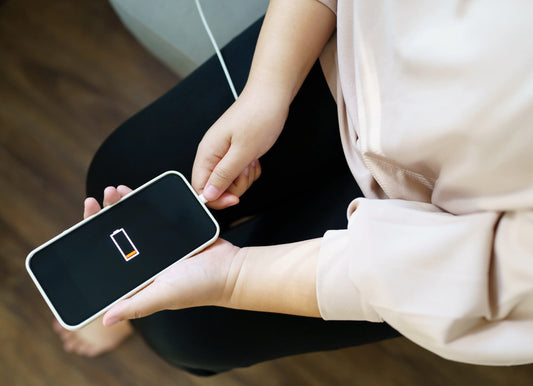 Joven preocupada porque su teléfono no carga al enchufarlo; revisa el centro de carga celular.